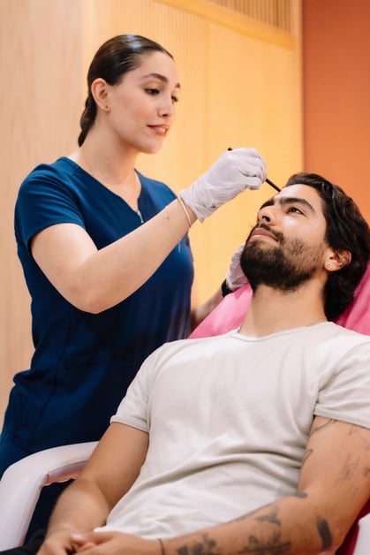 Médica realizando procedimento de harmonização facial em paciente.